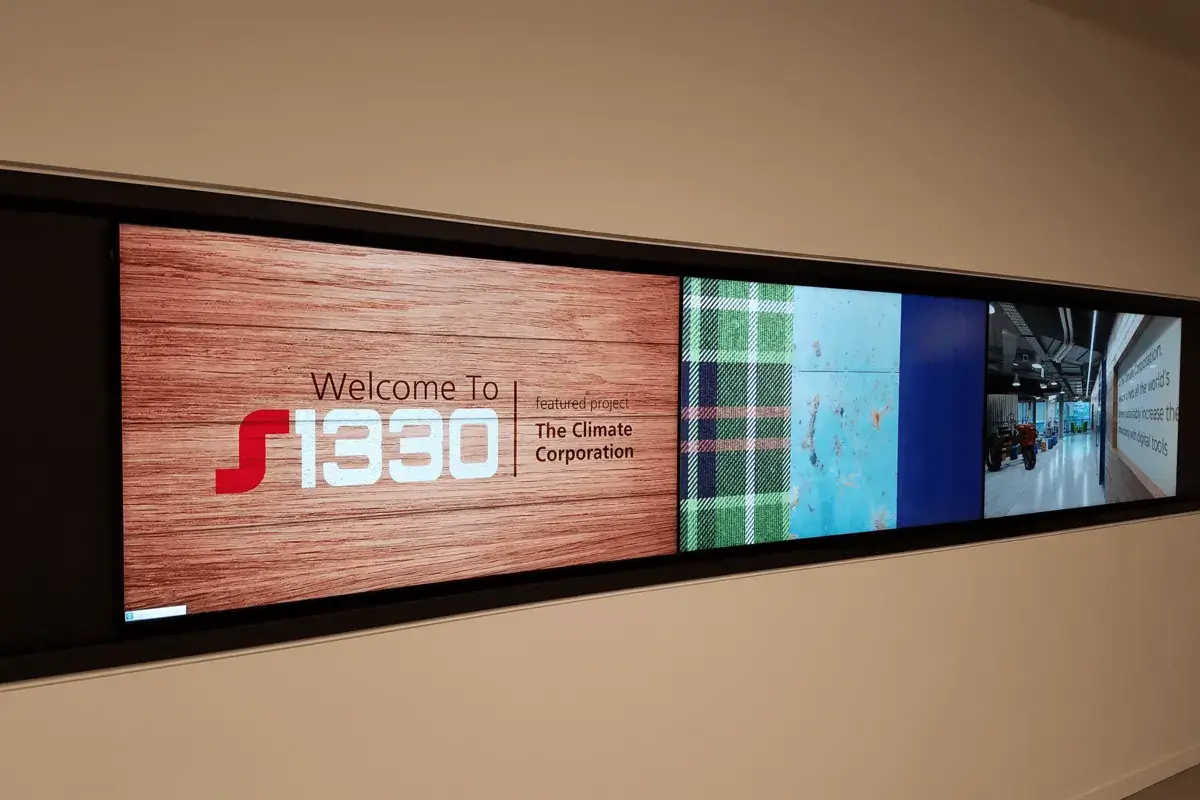 S1330 digital signage video wall from Reach Media Network displaying a building welcome message.