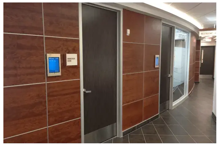 iPad digital signage screens from Reach Media Network used for room schedules.